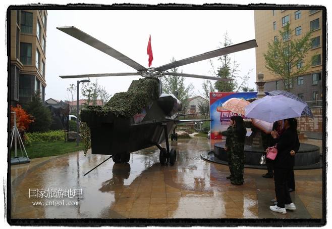 小區(qū)突然出現(xiàn)“飛機(jī)坦克”，其中殲15艦載戰(zhàn)斗機(jī)一架、99式主戰(zhàn)坦克一輛、武直-10武裝直升機(jī)一架，吸引了眾多市民雨中圍觀、合影。